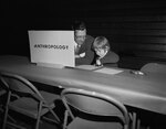 An adult and child at the Anthropology table during Parents Weekend by Indiana State University, University Archives