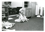 Child dressed up and playing with doll by Indiana State University, University Archives