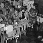 Teacher at table with students, some of which are in wheelchairs or with crutches by Indiana State University, University Archives